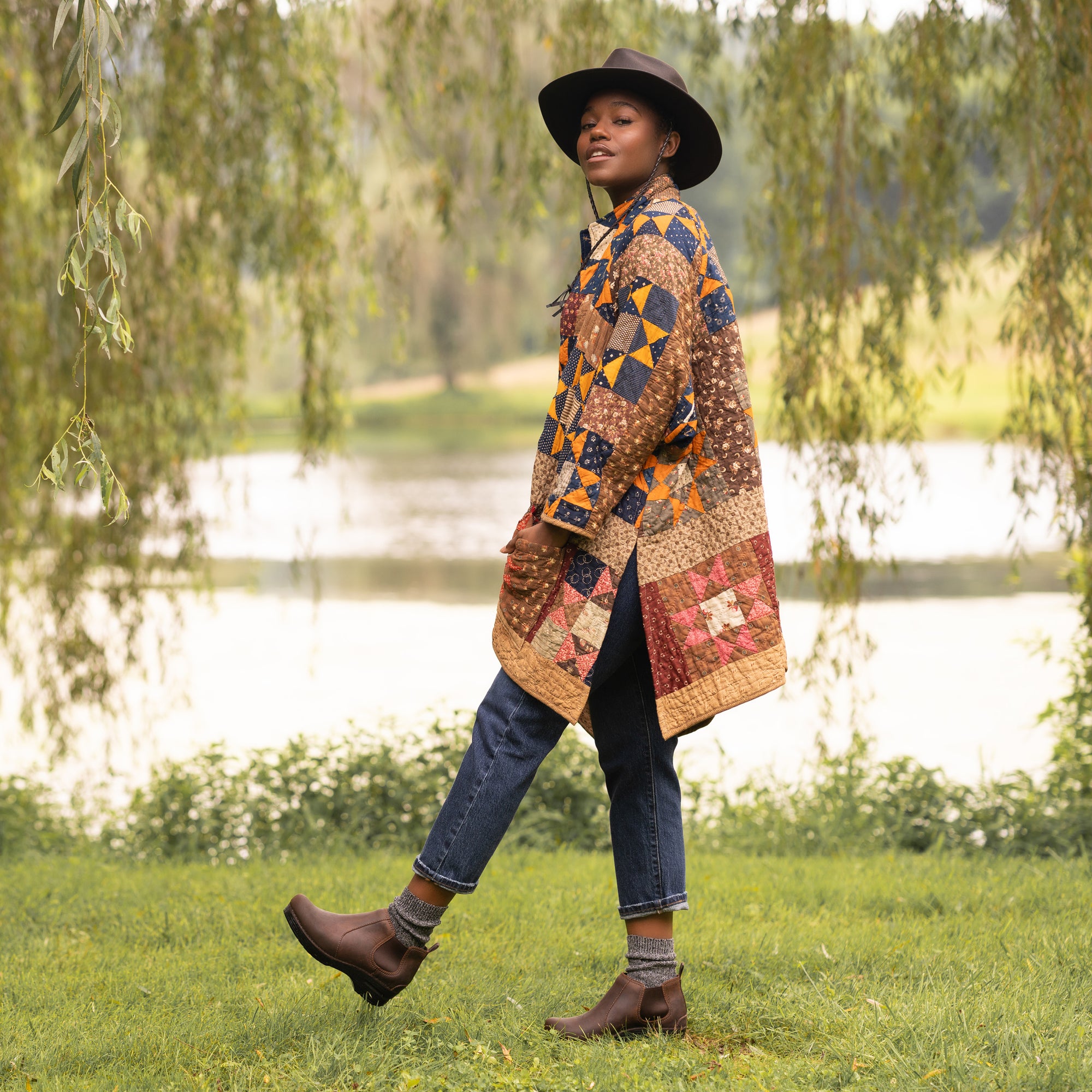 A woman in jeans and a quilt jacket wearing supportive and stylish brown boots.