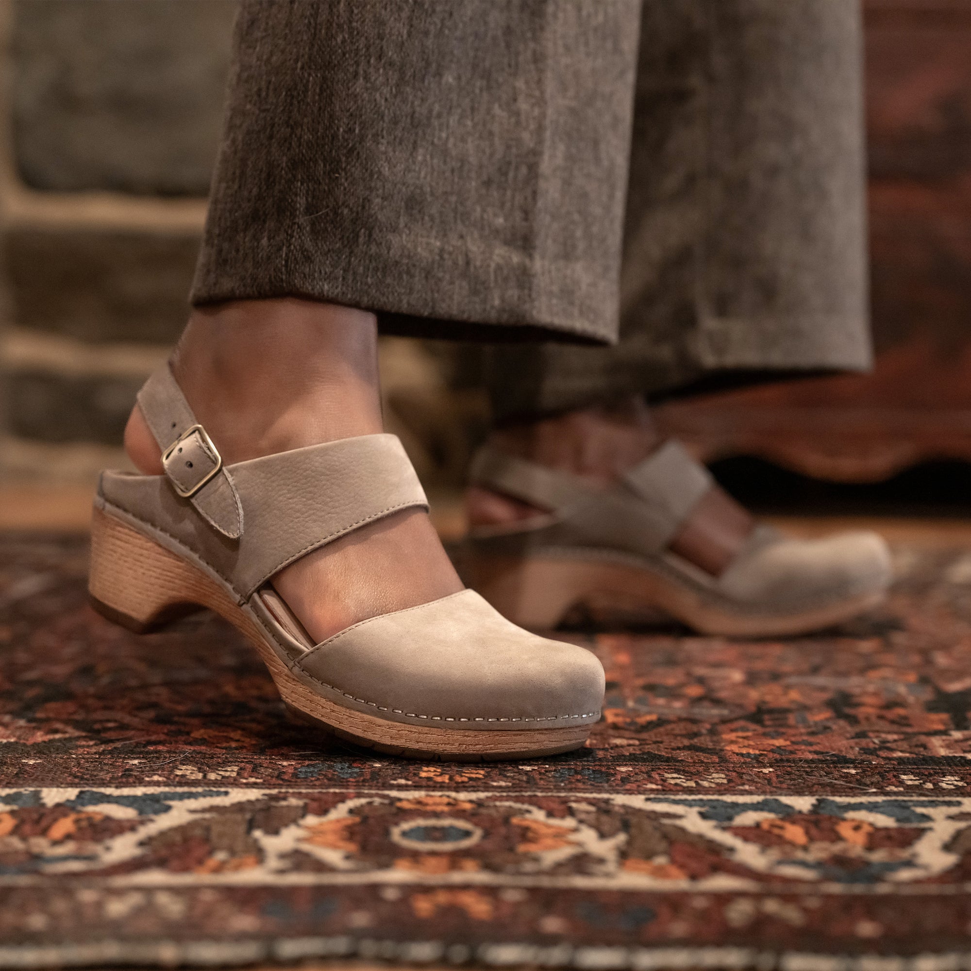 A close up of grey transitional sandals shown on foot.