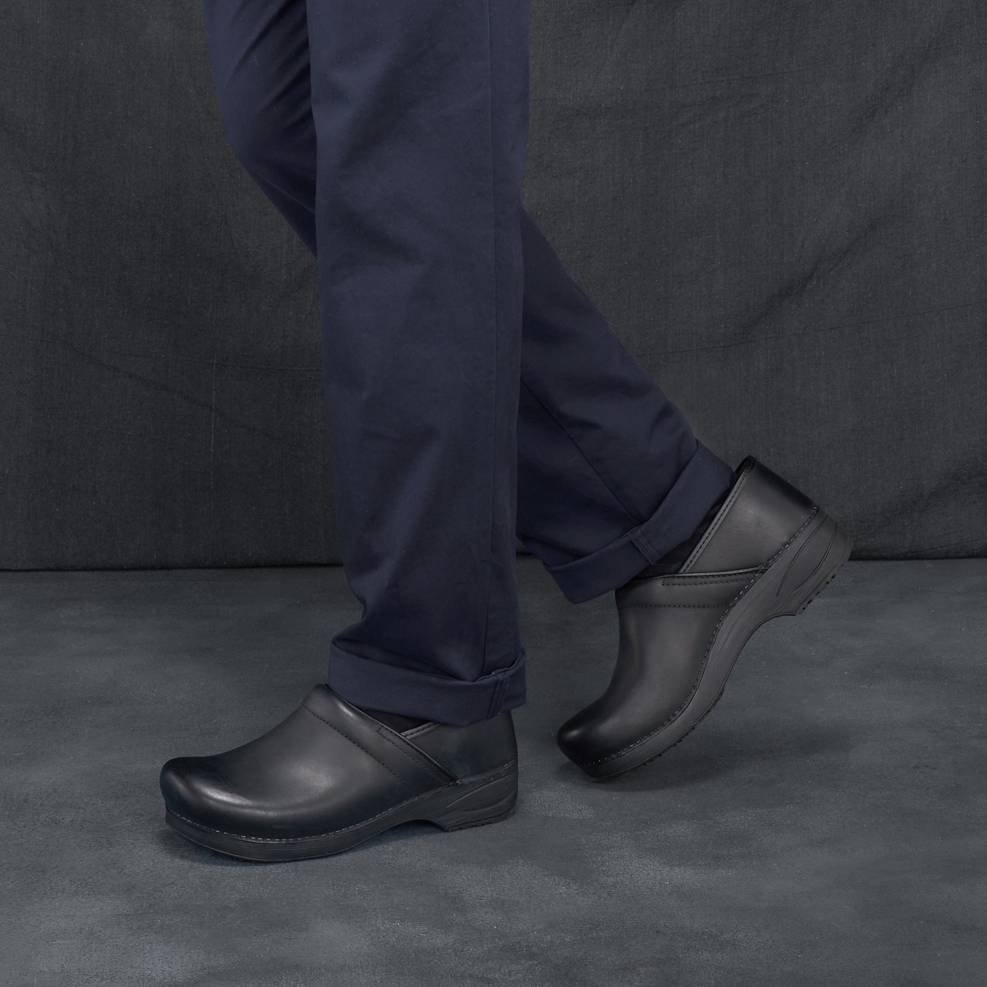 Black men's clogs worn in a casual setting.