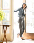 A woman entering a cafe with metallic silver ballerina flats and a casual outfit.