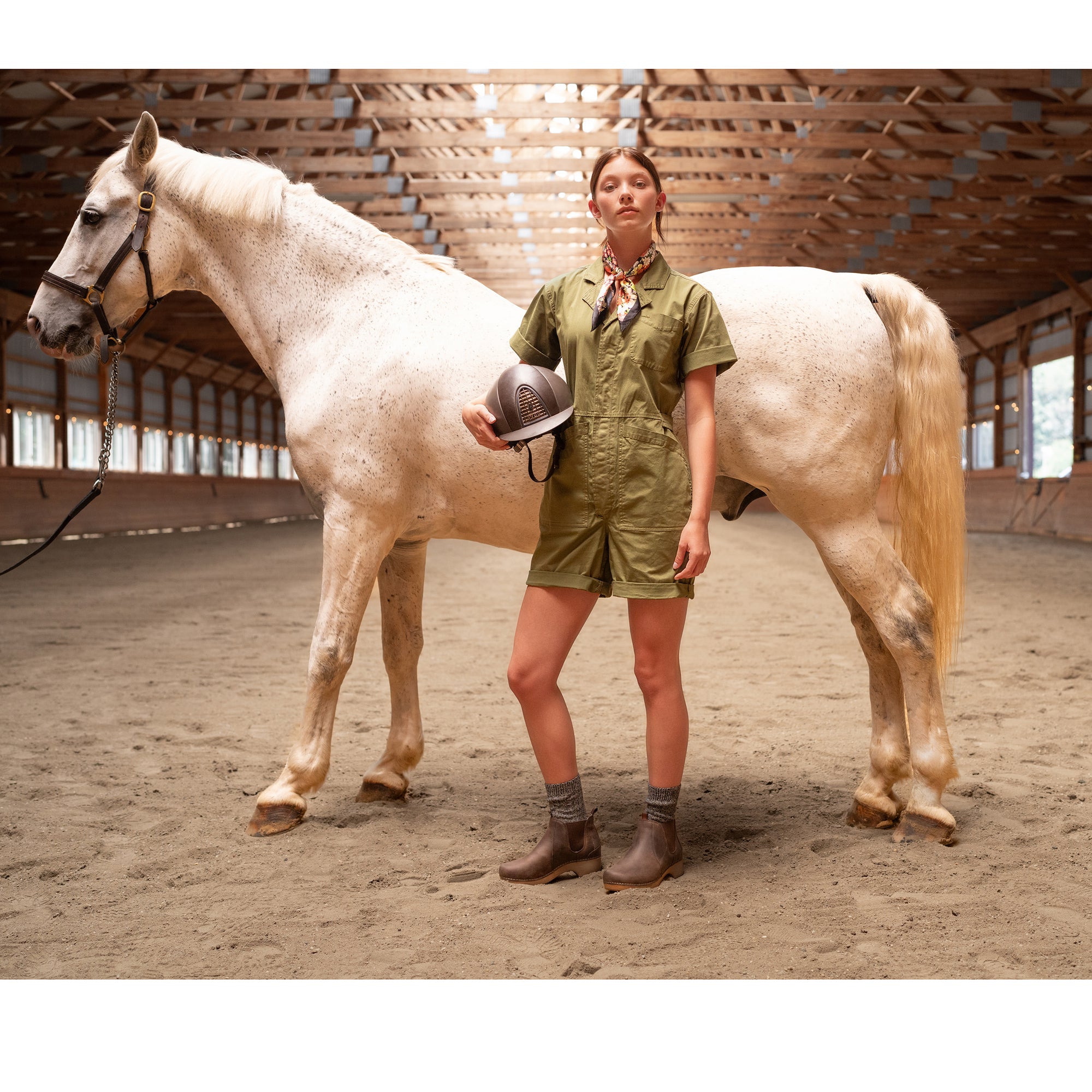 Woman with horse wearing stylish brown booties with grey wool socks.