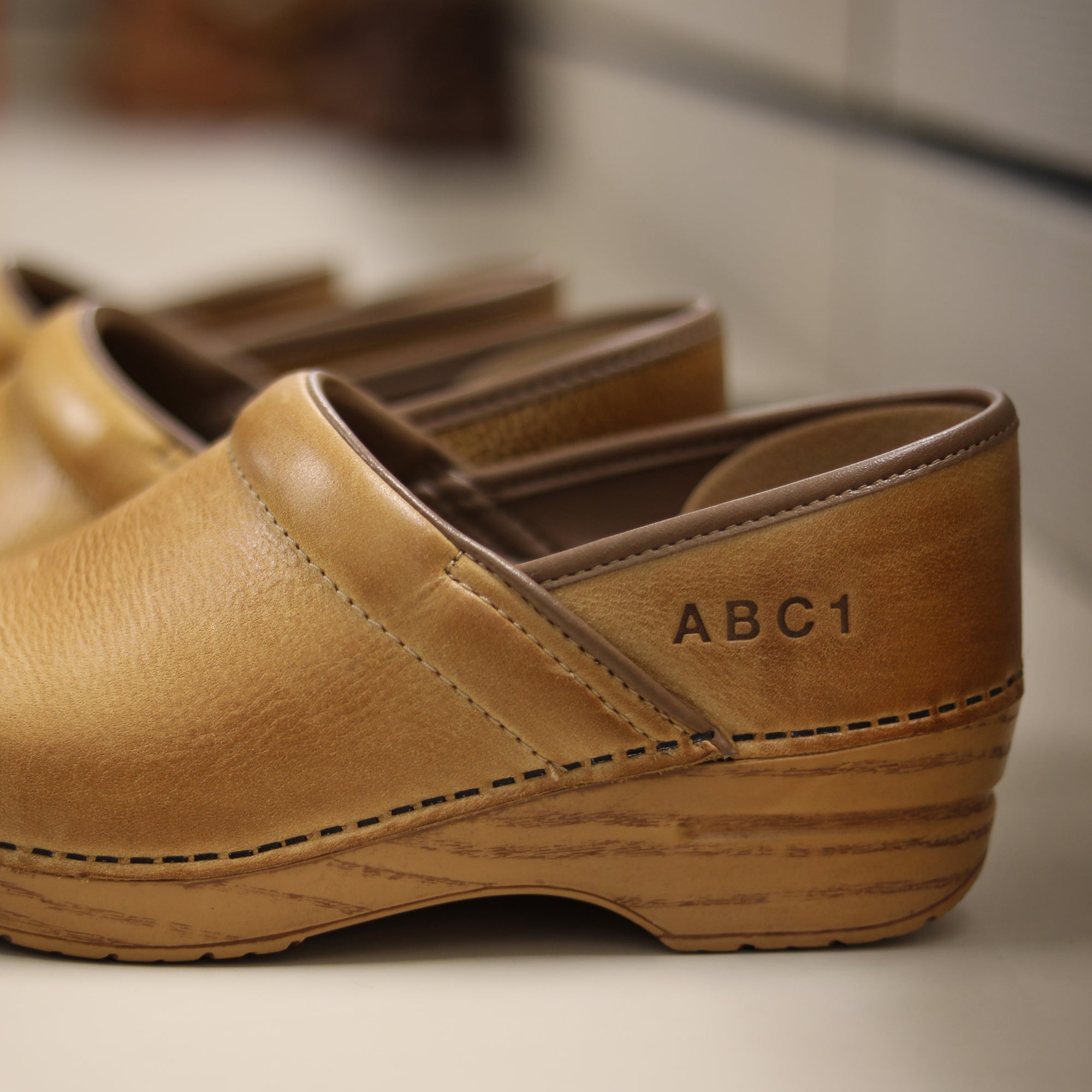 A sample personalization shown on honey distressed clogs.