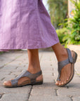 A closeup of metallic leather toe-post sandals.