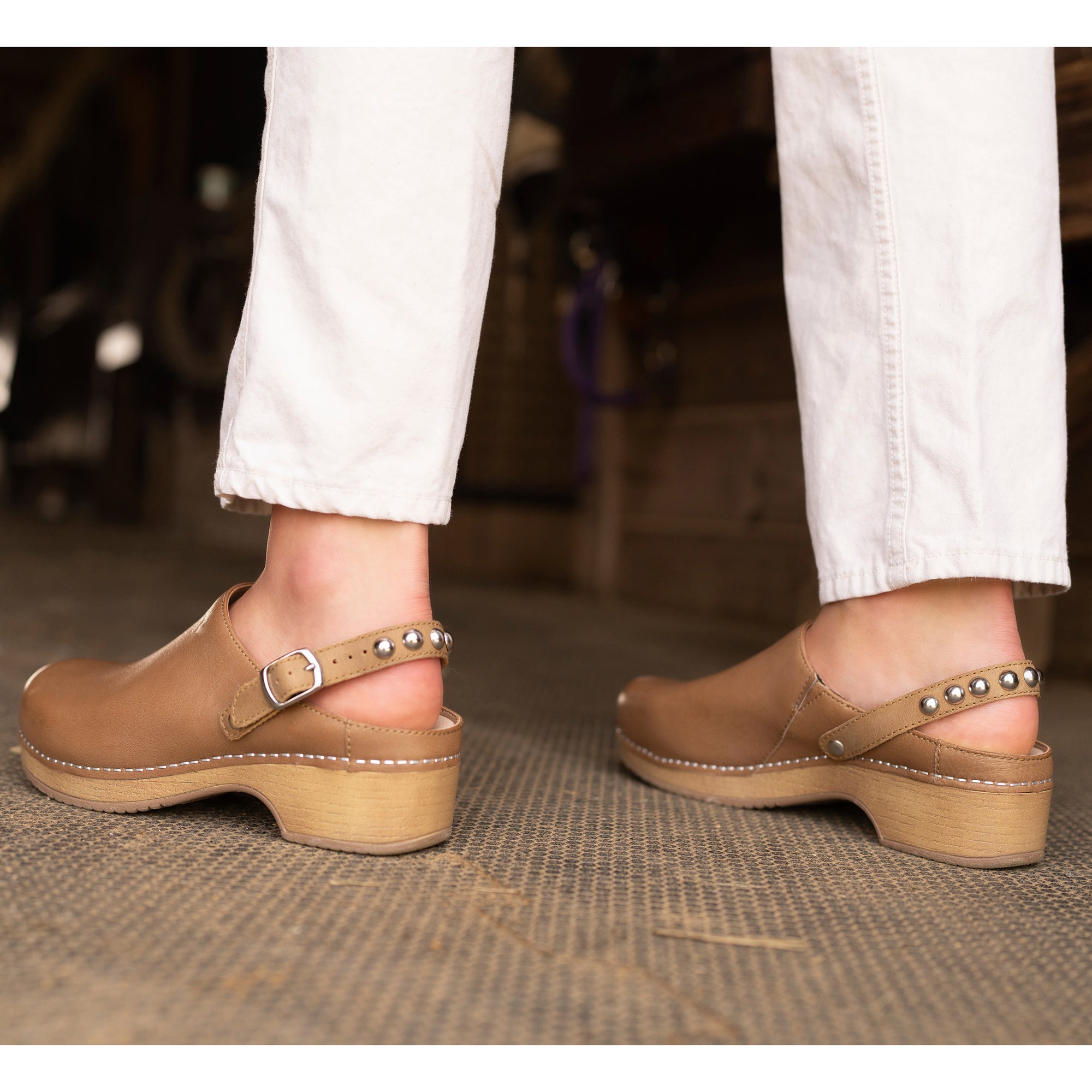 Tan mule clog with slingback strap and stylish hardware.