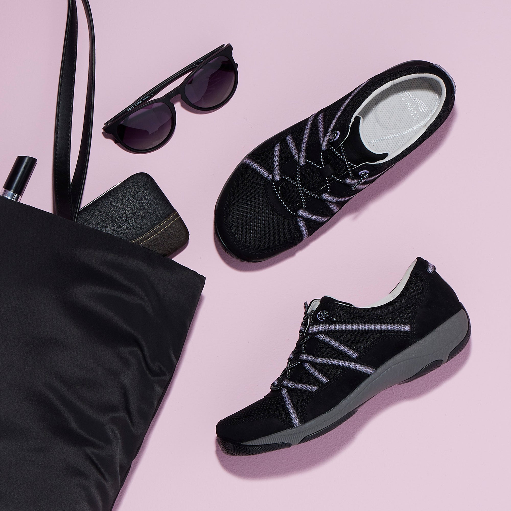 A black sneaker shown with a travel bag to say it is lightweight and great for travel.
