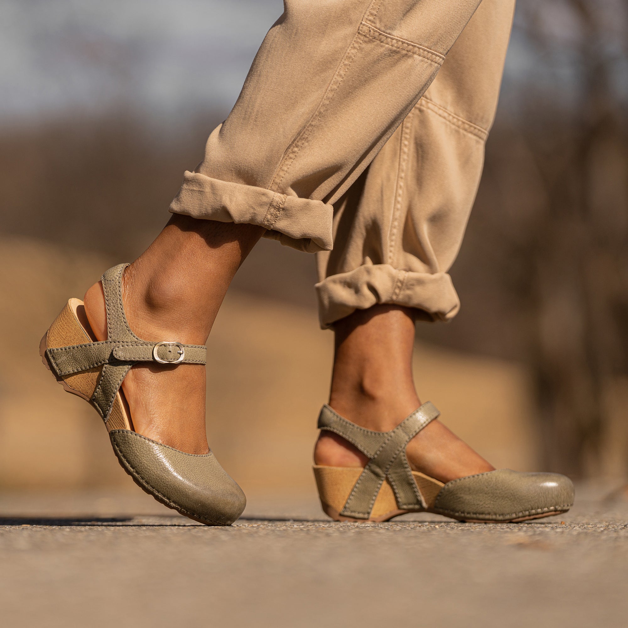 A closeup of neutral earthtone transitional flatform sandals shown on foot.