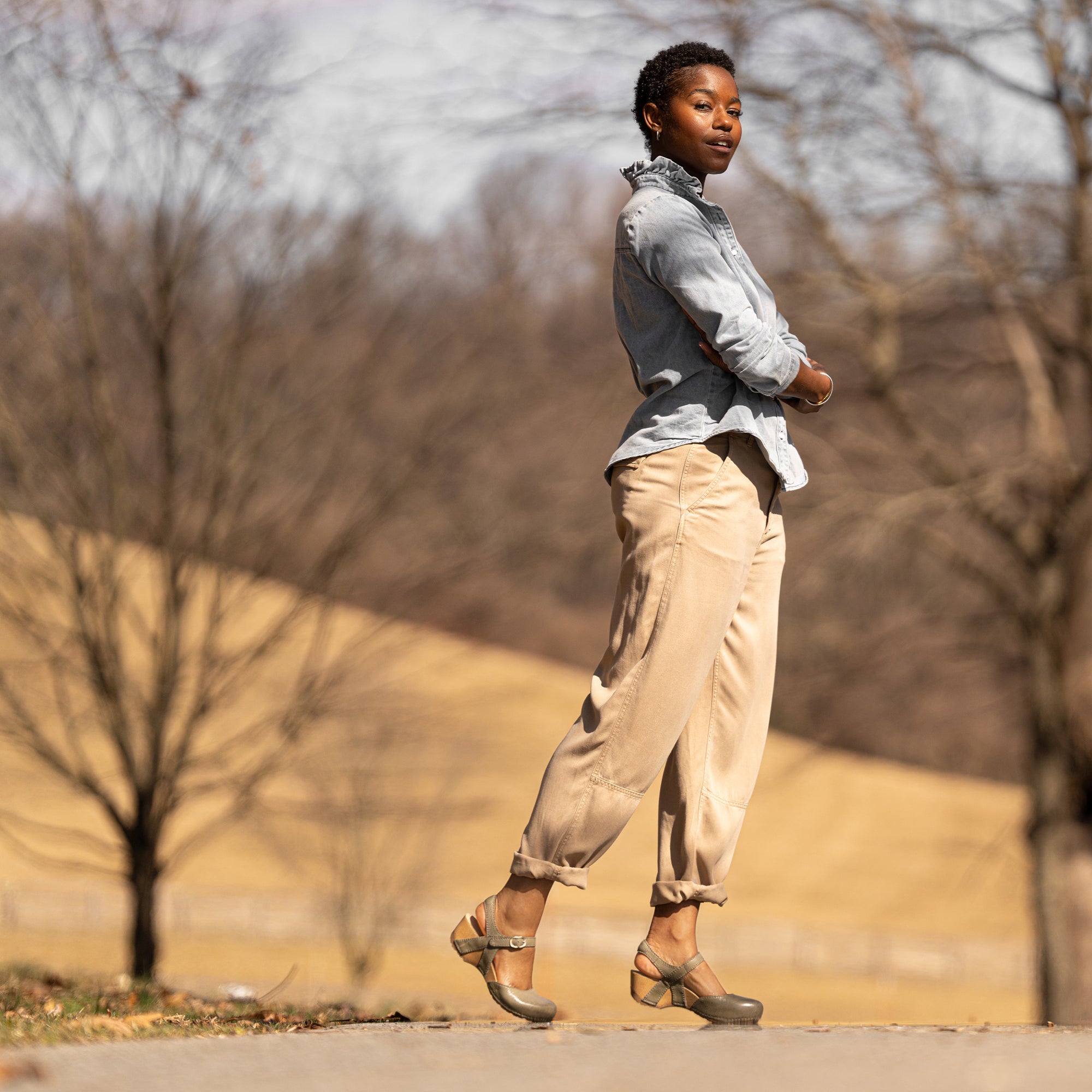 A woman wearing flatform transitional sandals in a calming neutral earthtone.
