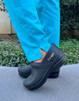 A nurse wearing black personalized clogs.