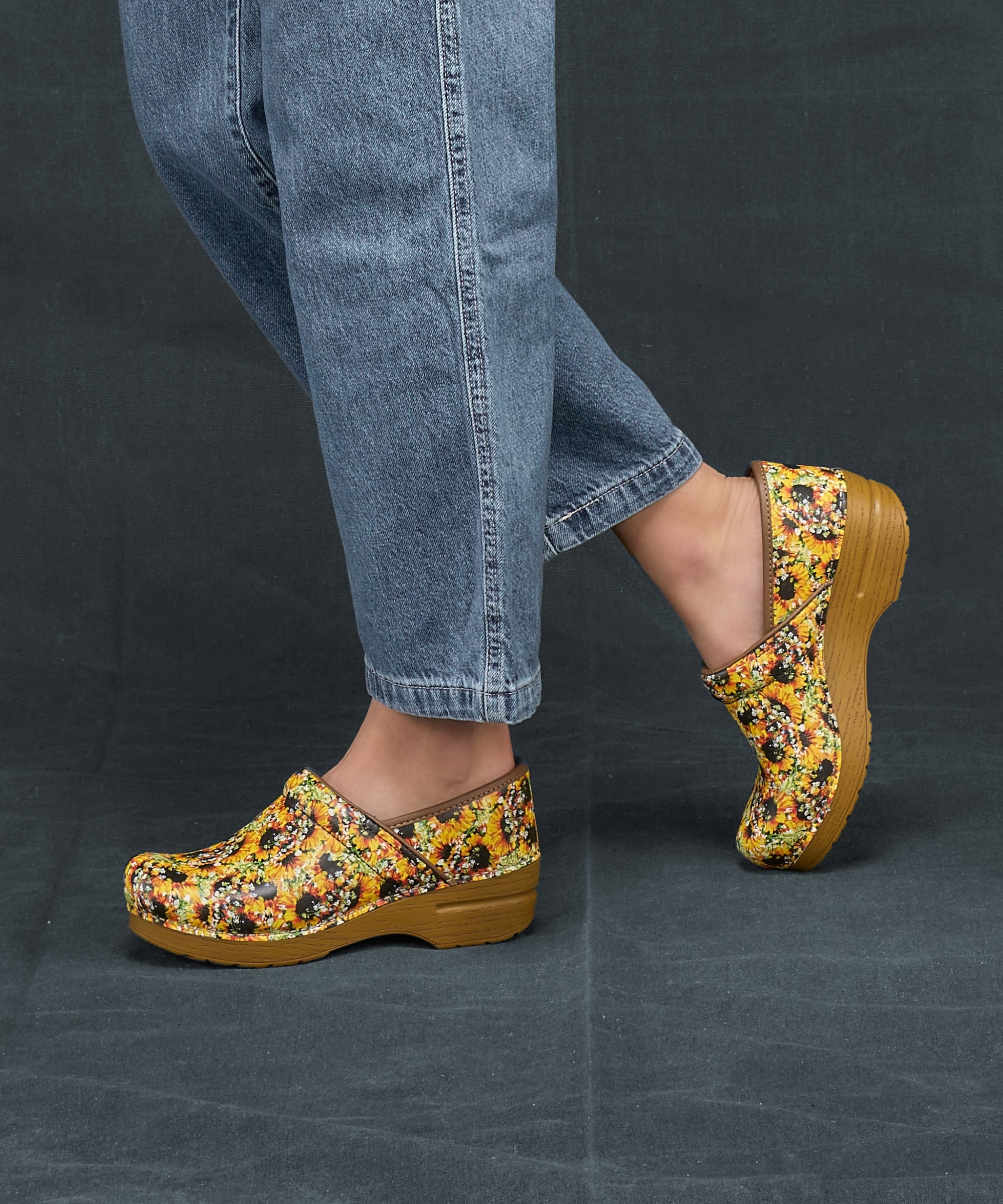 A closeup of sunflower leather clogs on faux wood soles.