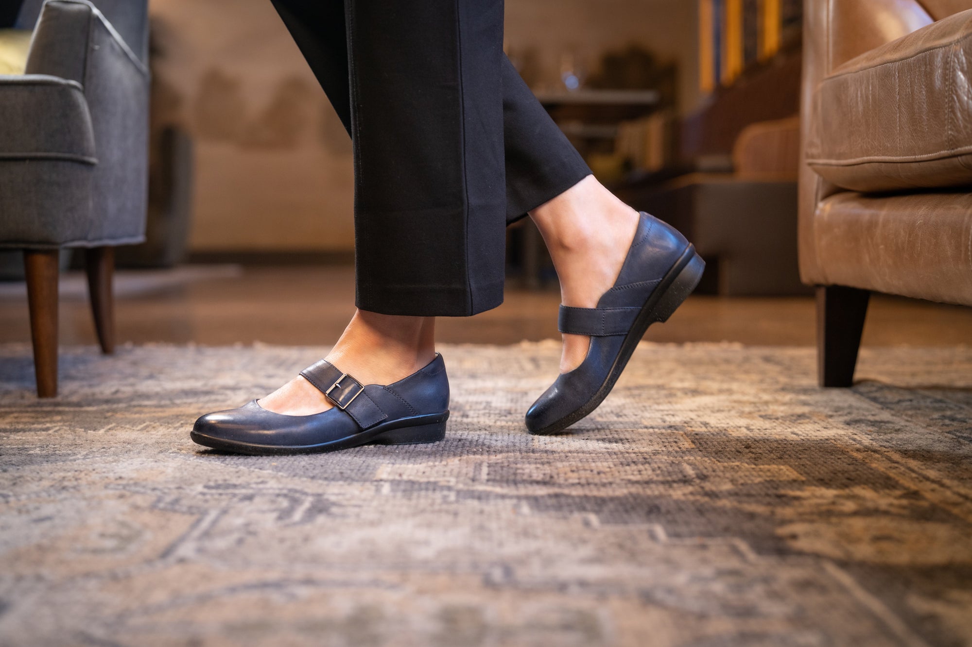 Close up of tan flats on a woman wearing blue jeans.