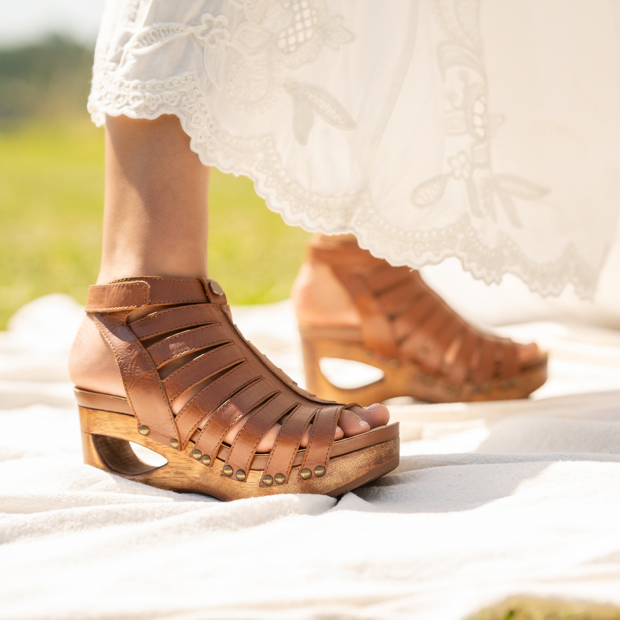 Close up of tan strappy sandals with wood bottoms.