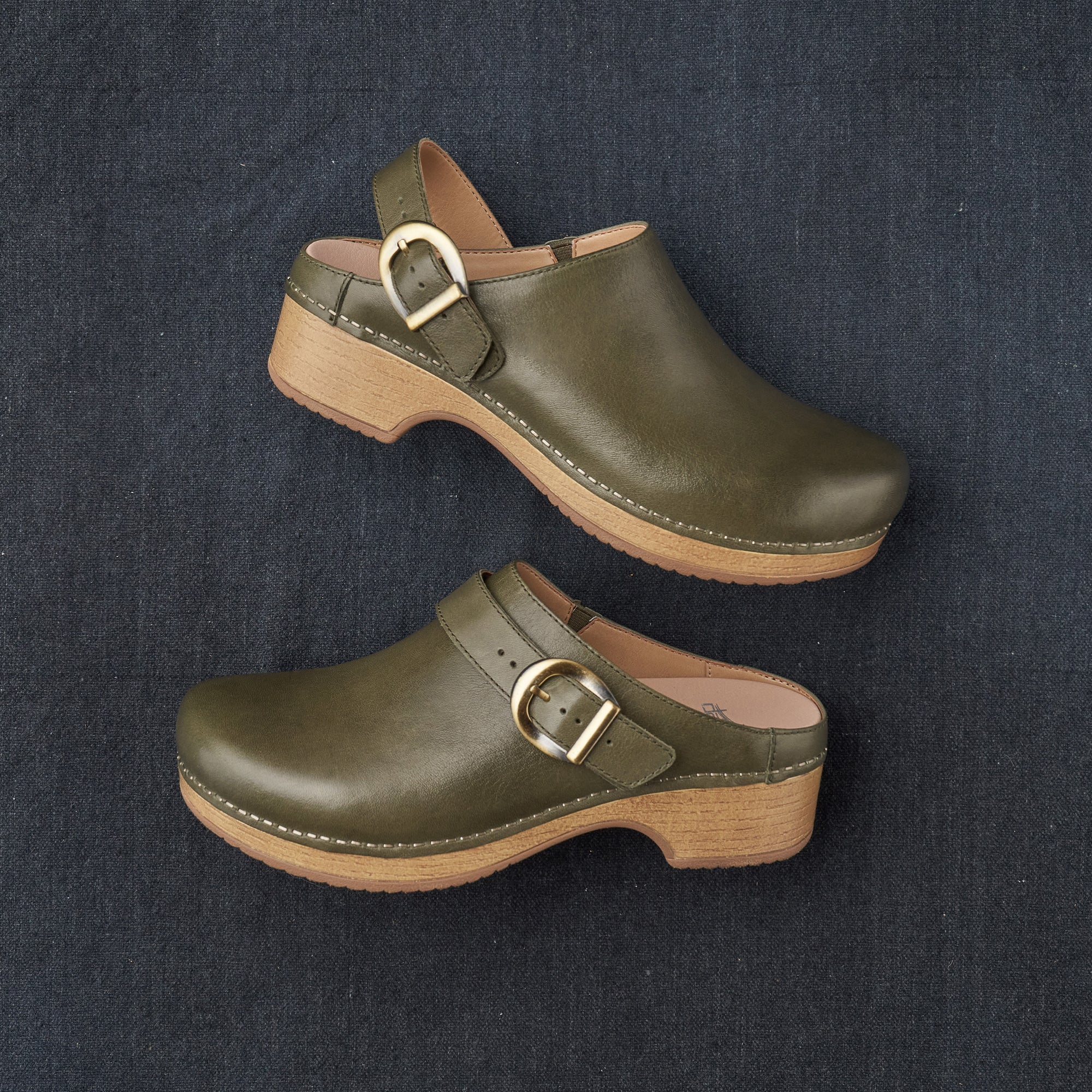 A look at the slingback style of these green mule clogs with a swivel strap.