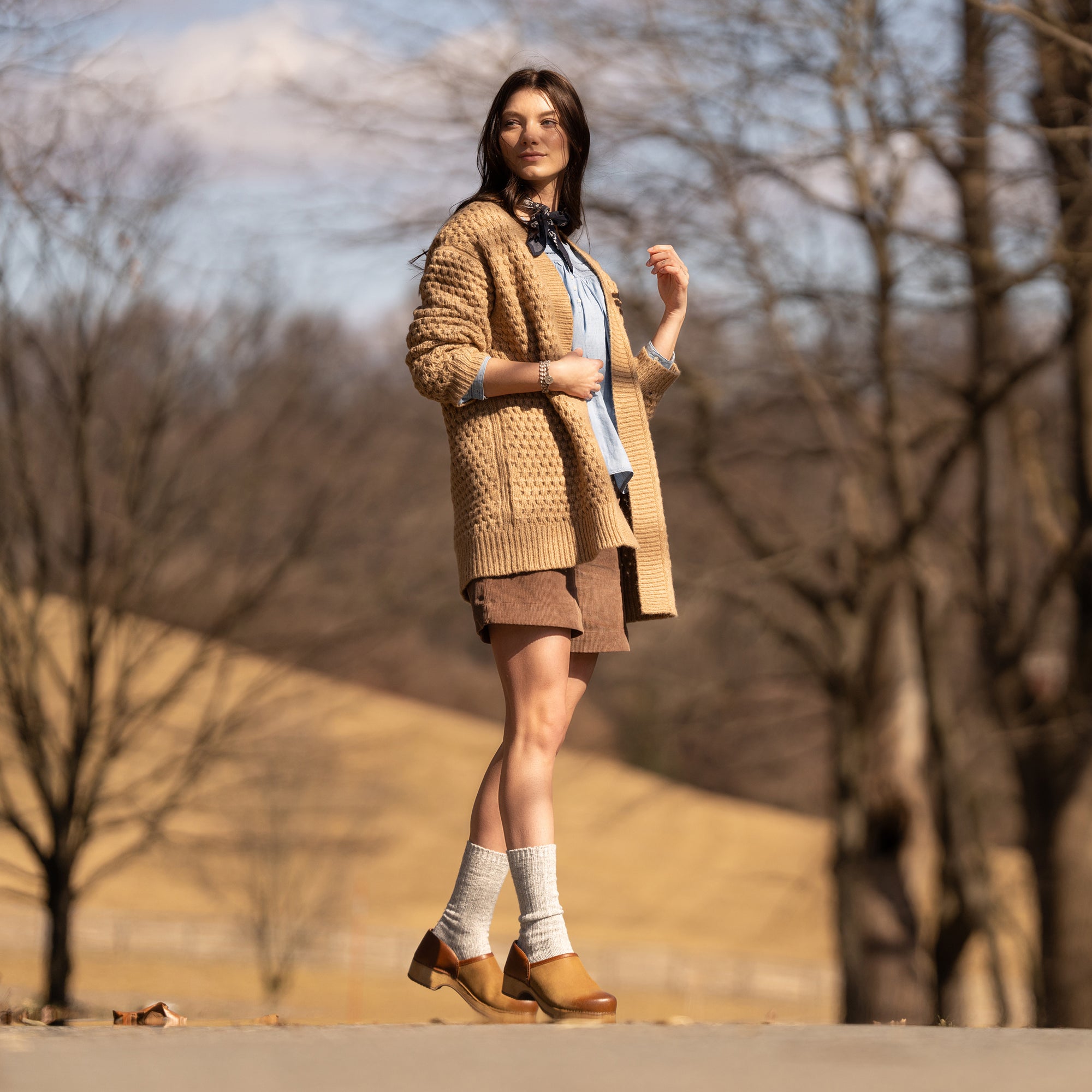 A woman in cute fall fashion wearing stylish tan clogs.