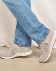 A pair of lightweight grey sneakers shown on foot.