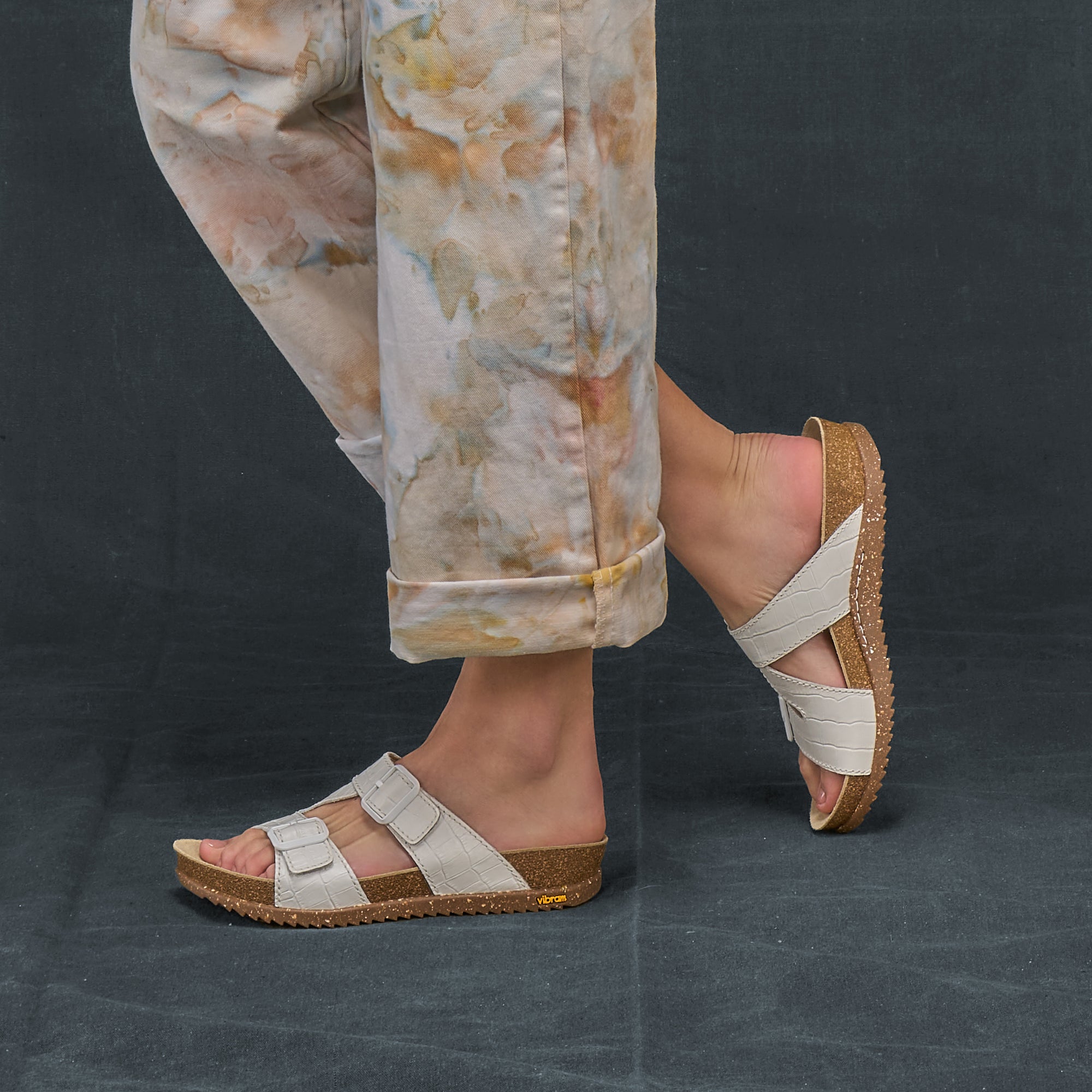 A closeup of cork-footbed sandals with white leather uppers.