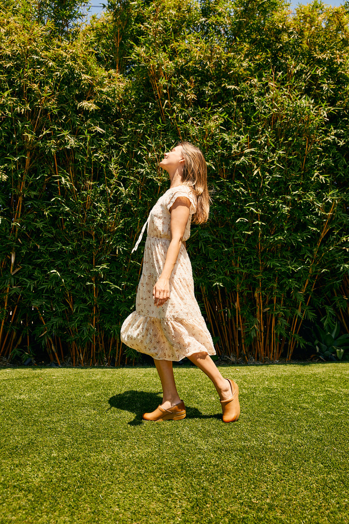 A woman wearing classic closed-back clogs that look great with her sundress.