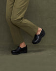 Classic black clogs shown on foot.