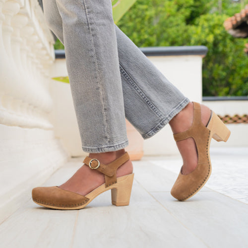 A close up shot focusing on stylish brown sandals with a faux wood sole.