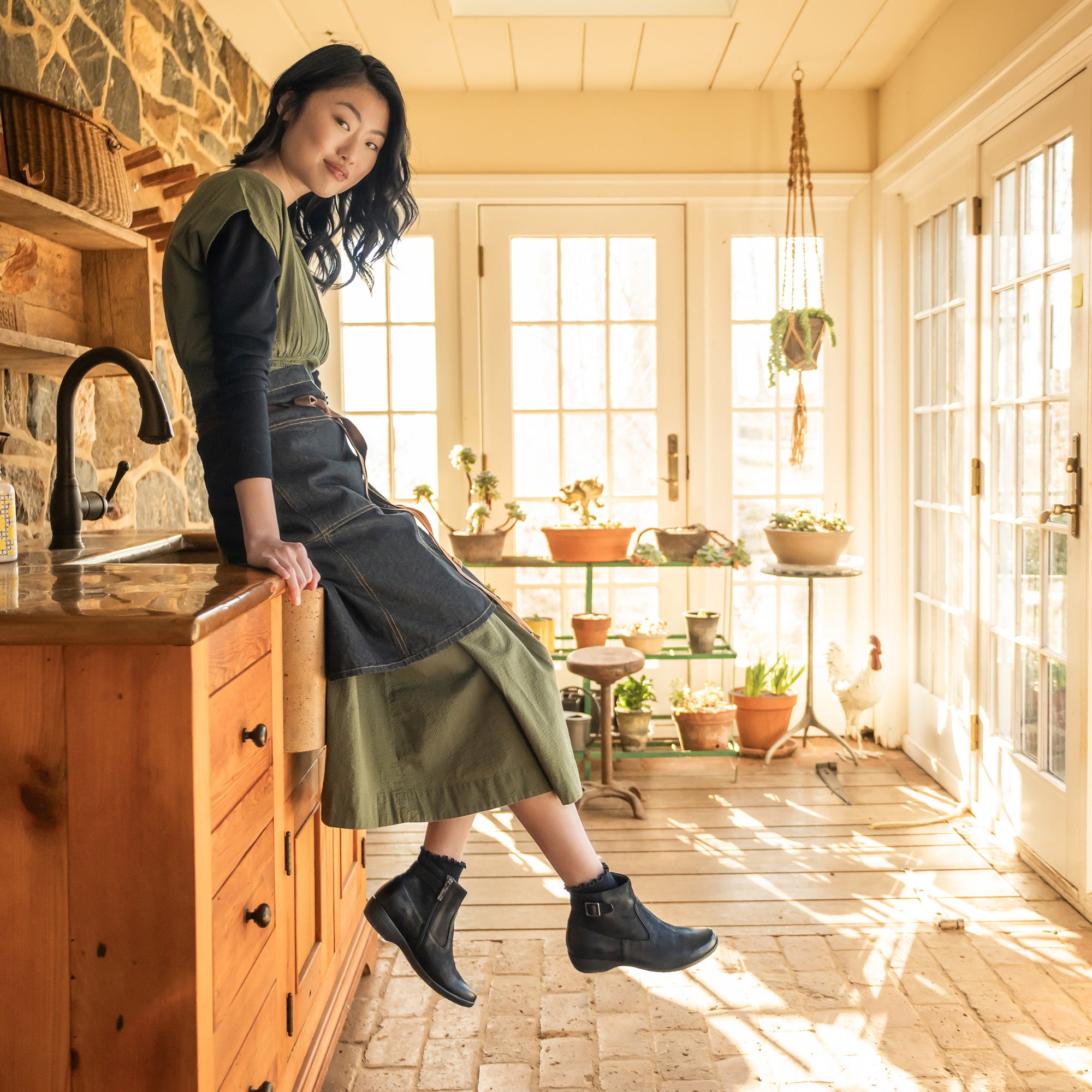 A gardener wearing black booties with a subtle buckle.