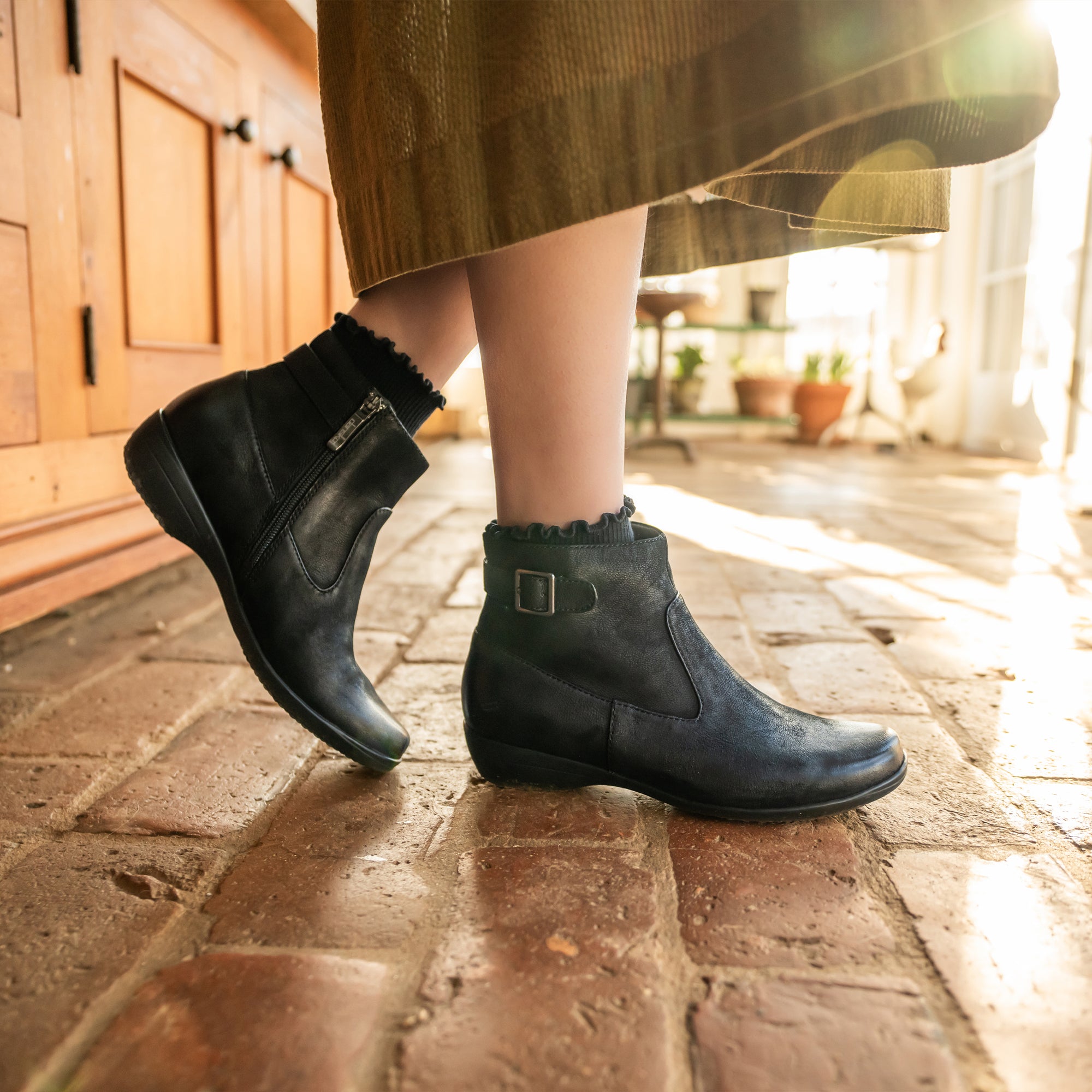 A close-up look at black booties with an inside zipper.