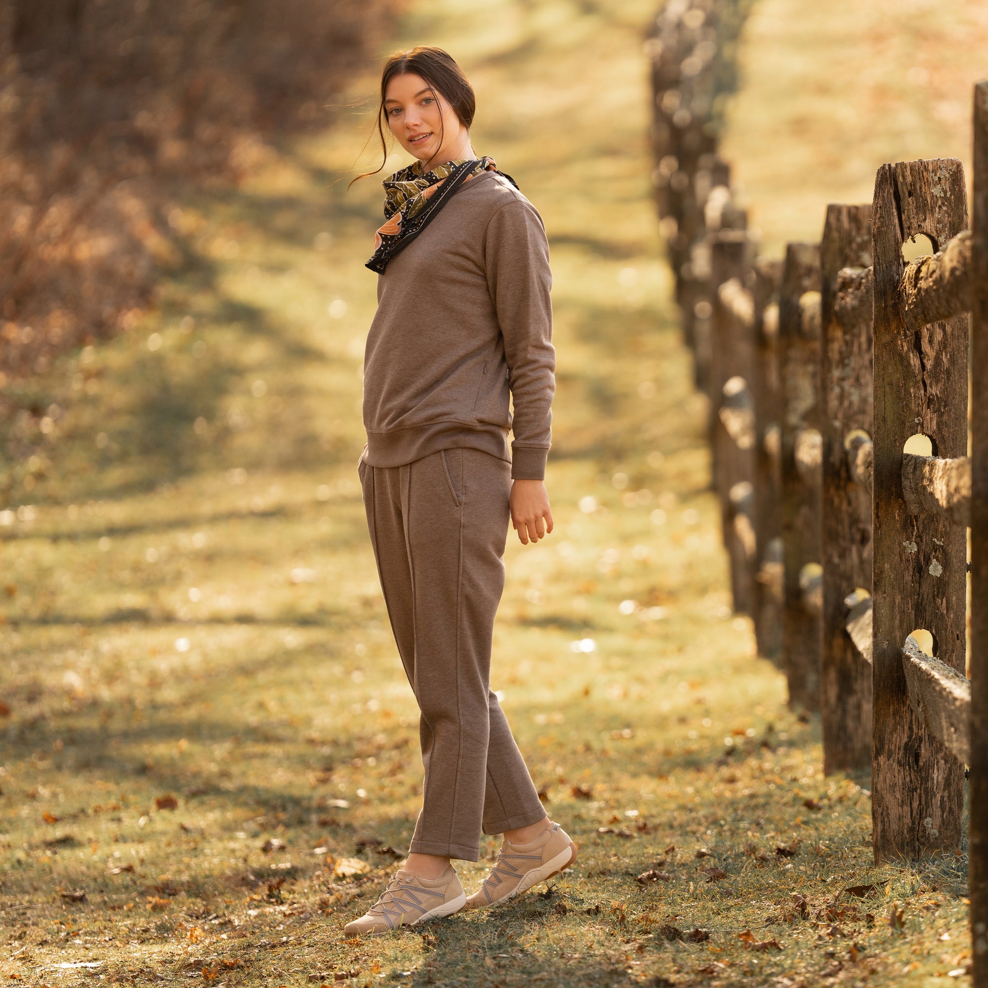 A woman wearing casual outdoor attire and compact, lightweight sneakers.