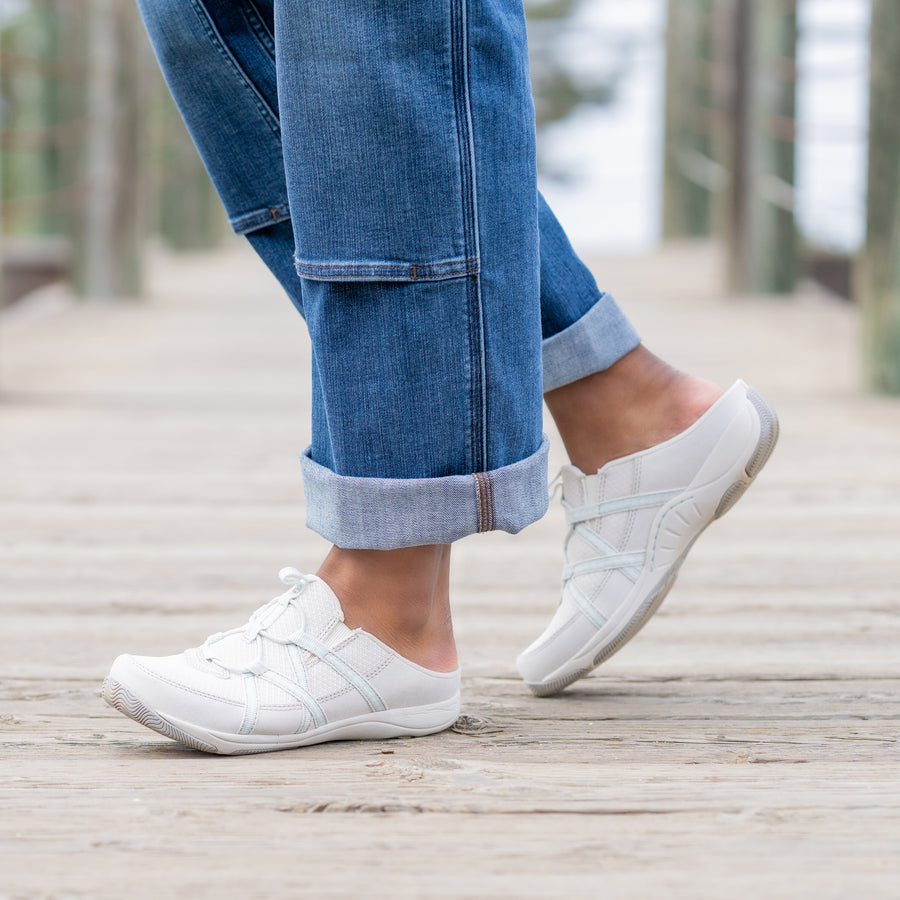 A close up on thin white slip-on sneakers.