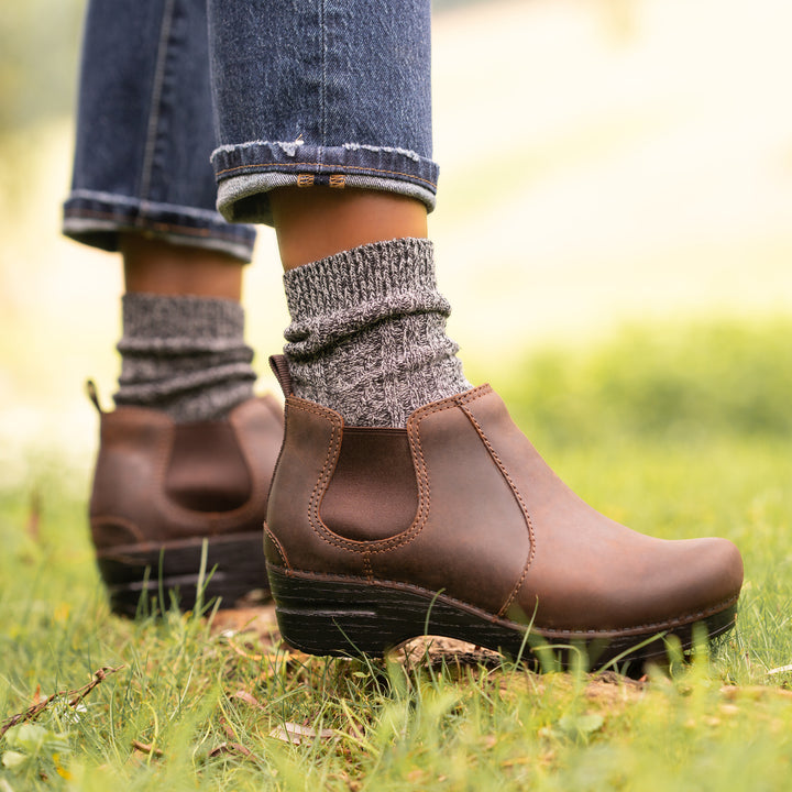 Stylish brown boots worn with grey wool socks.