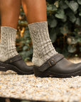 Black mule clogs with an adjustable strap styled with grey wool socks.