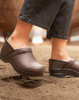 Brown Professional clogs from Dansko styled with black jeans.
