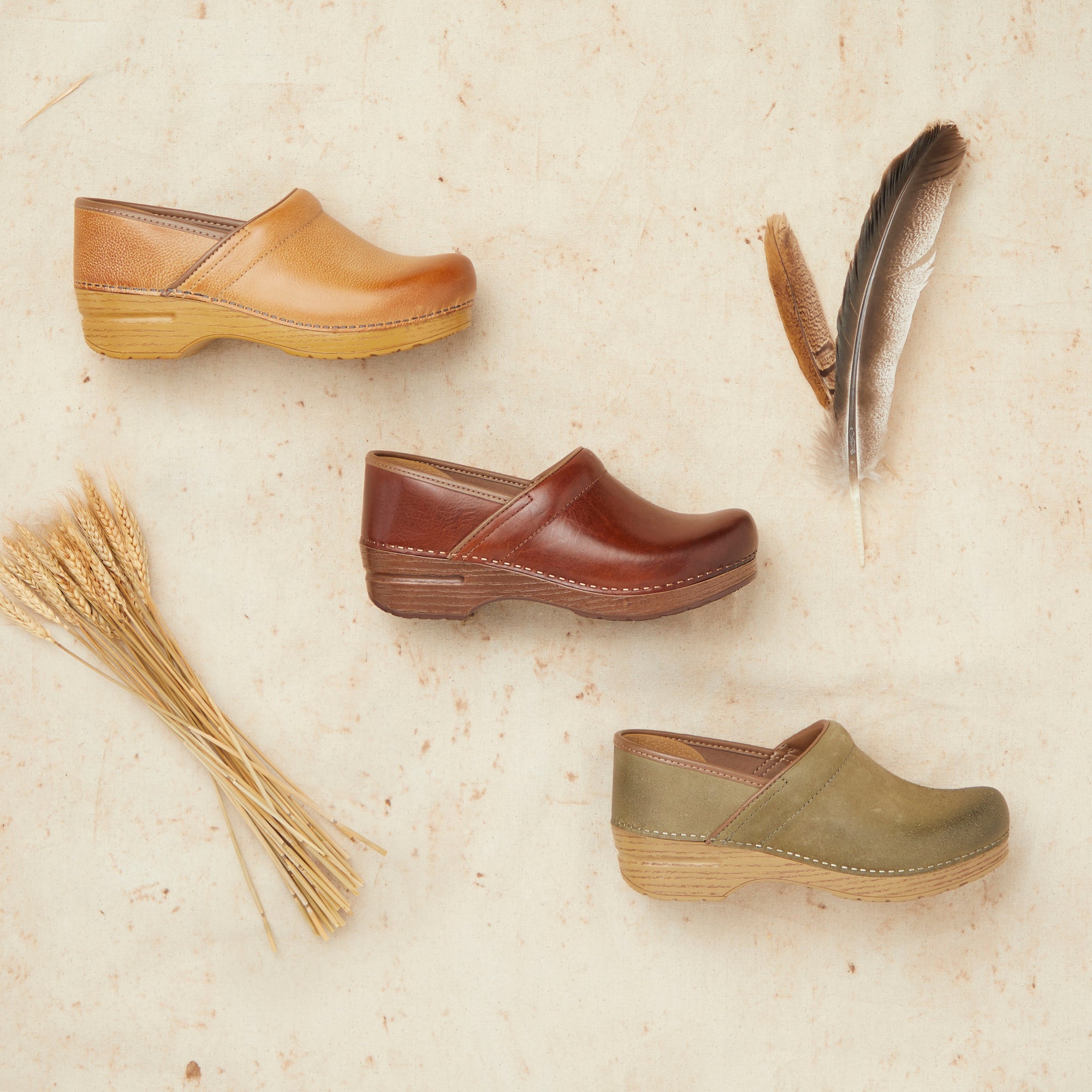 A light brown clog, a rich brown clog, and a green clog from Dansko.