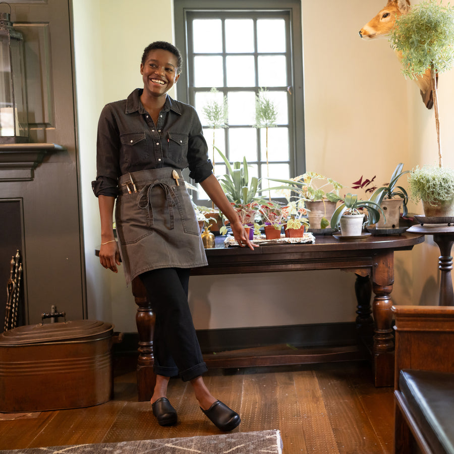 A gardener wearing black backless clogs while working.