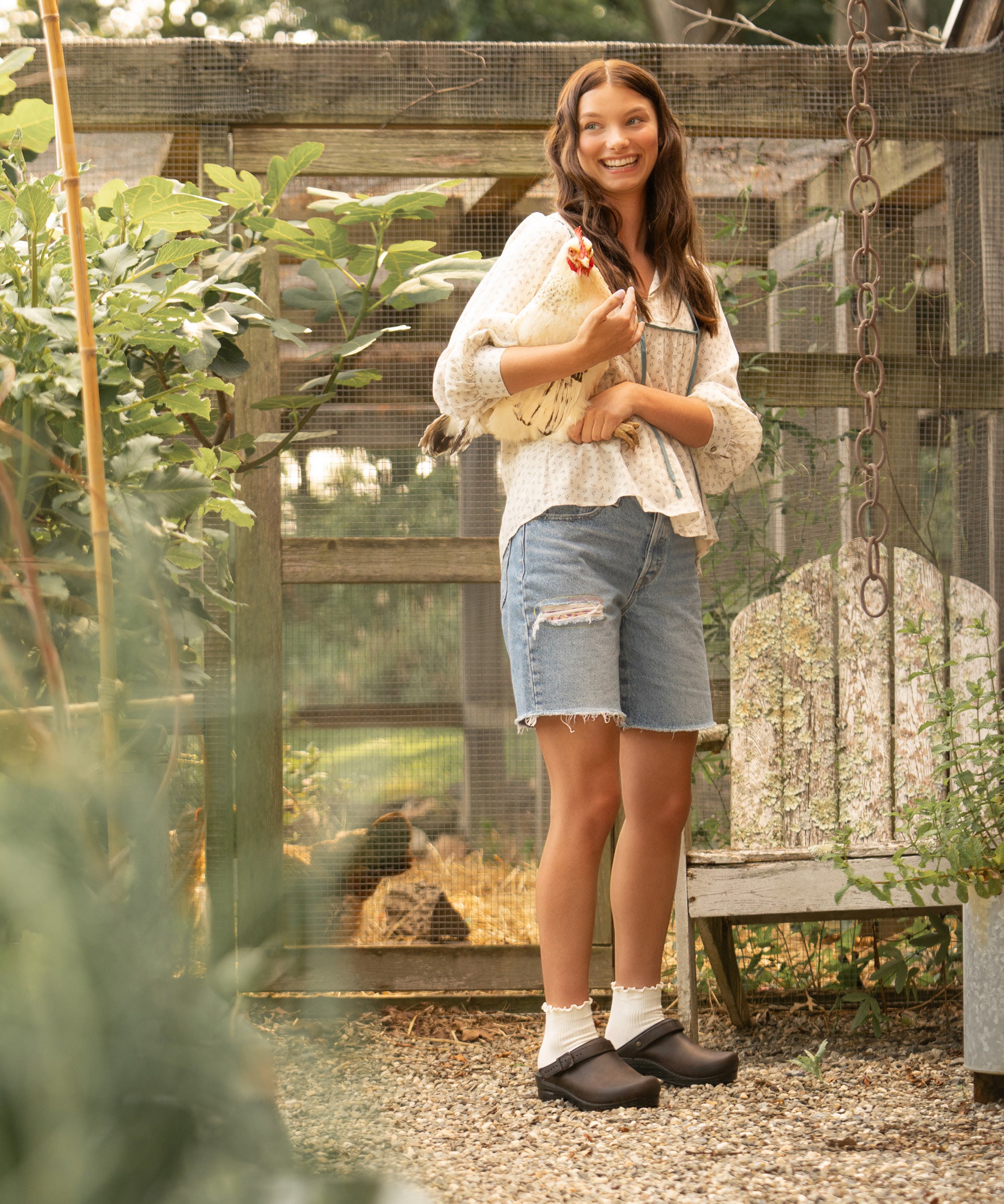 A woman dressed to care for animals wearing brown swivel strap clogs styled nicely with cute white socks.