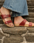 Close up of red strappy flat sandals.