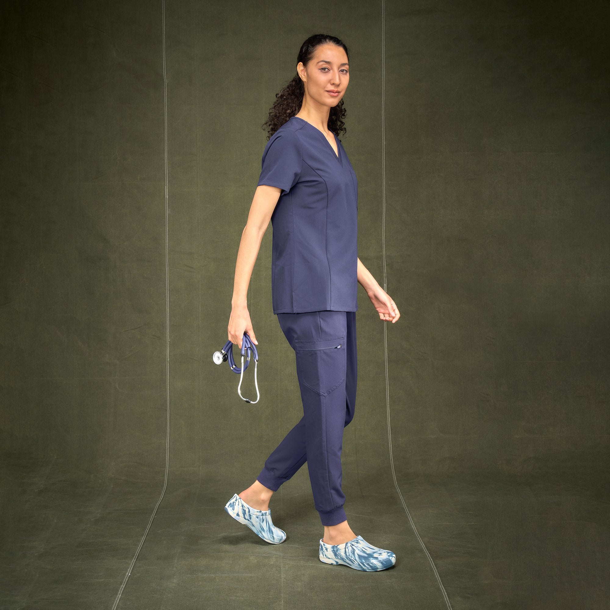 A doctor in scrubs wearing blue and white tie-dye molded clogs with slip resistance.