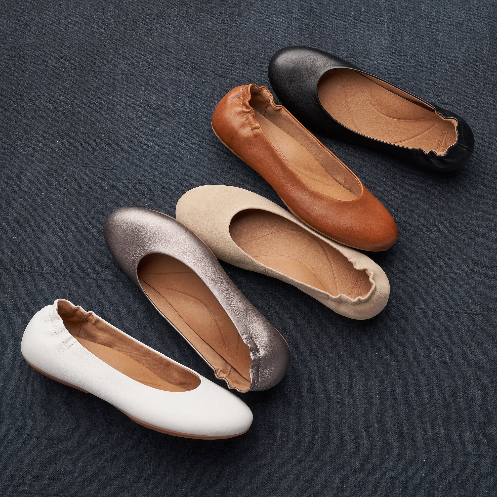 Five color options of a new ballerina flat with arch support and leather design featured.