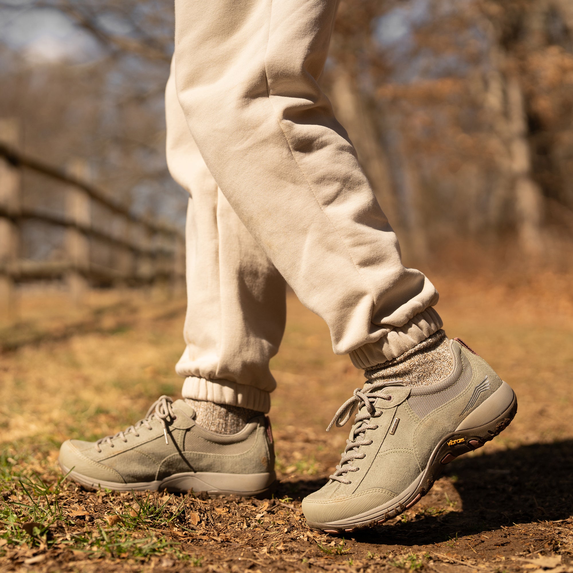 A closeup of sage outdoor sneakers shown on foot.