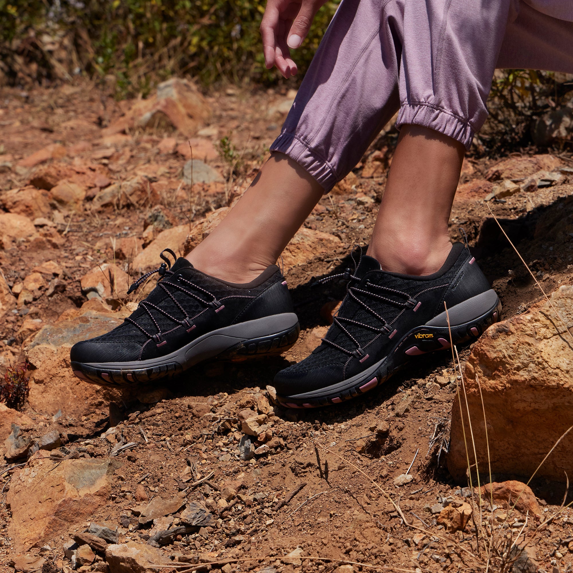 An on-foot look of black, lightweight outdoor sneakers with durable rubber outsoles.