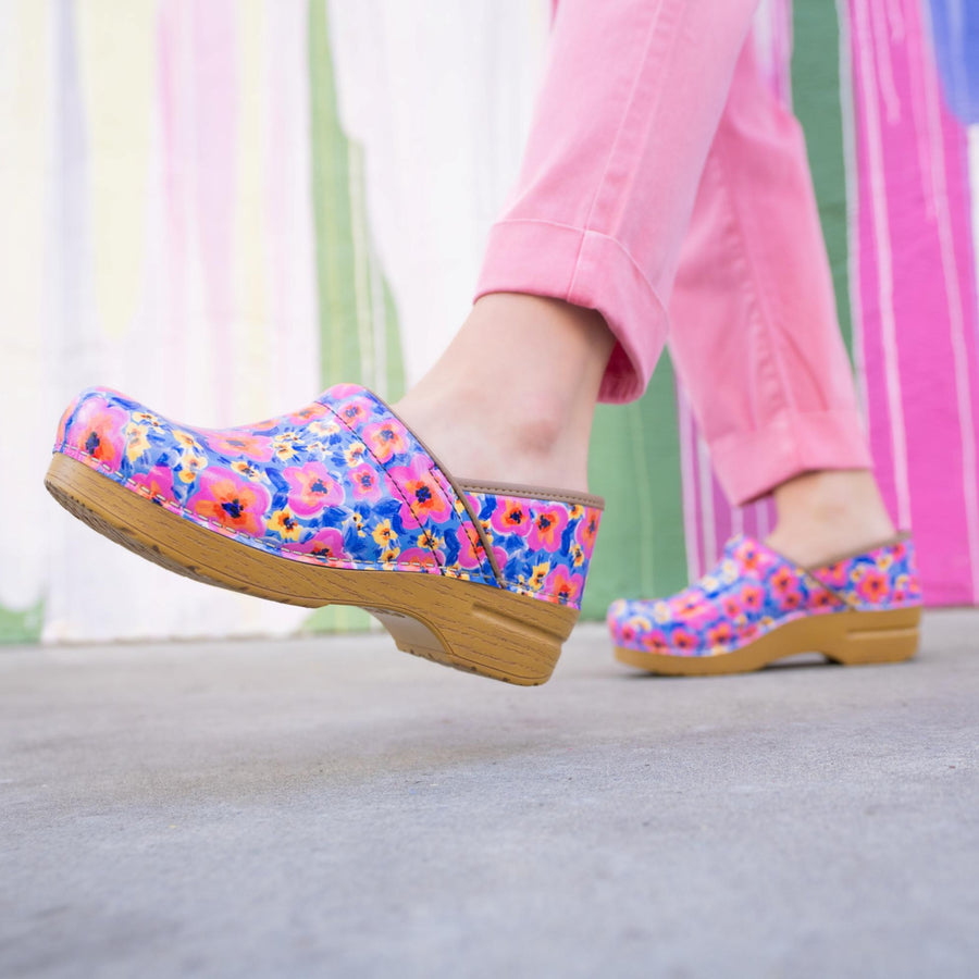 Patent clogs with a faux wood sole and springtime flowers.