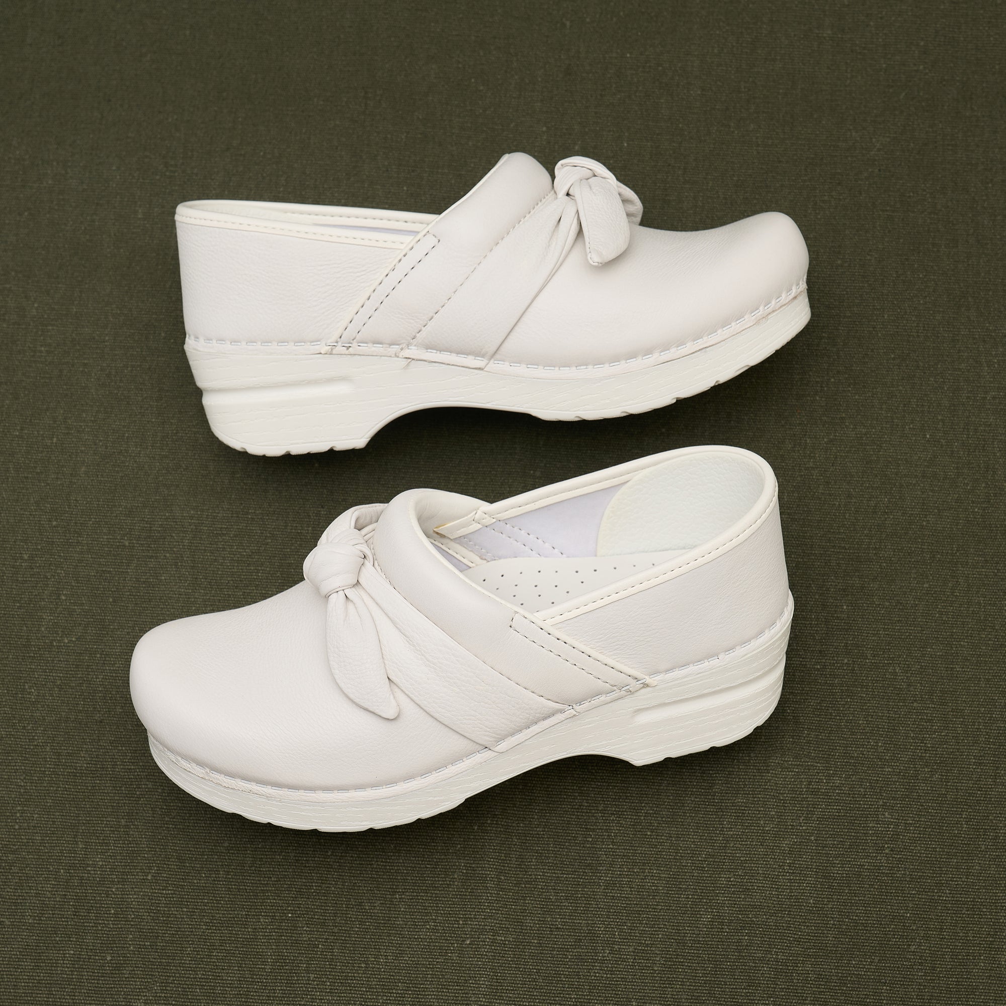 White clogs with a bow detail.