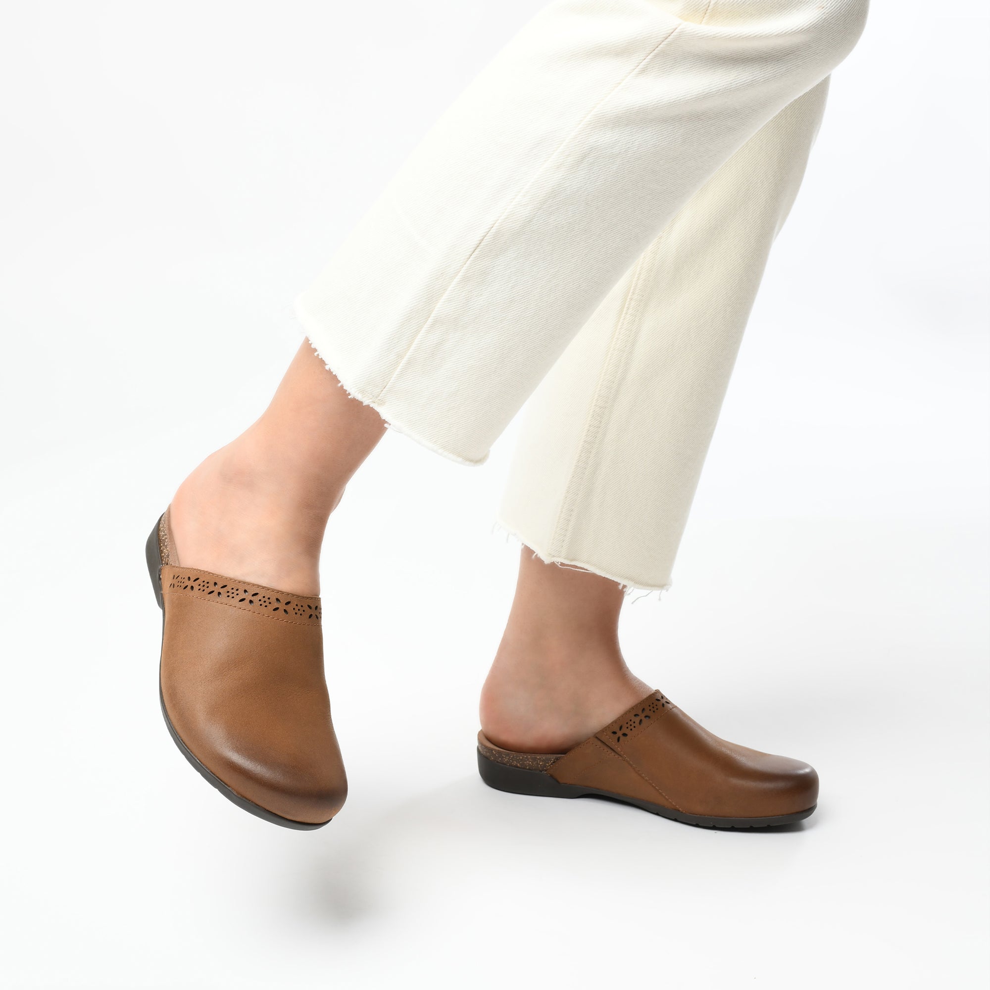 Brown mules with cutout design shown on foot.