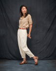 A woman in a monochromatic earth tone outfit wearing brown leather transitional sandals.