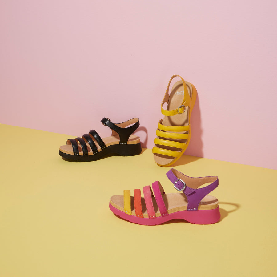 Three strappy sandals shown in black, yellow, and a multi pattern.