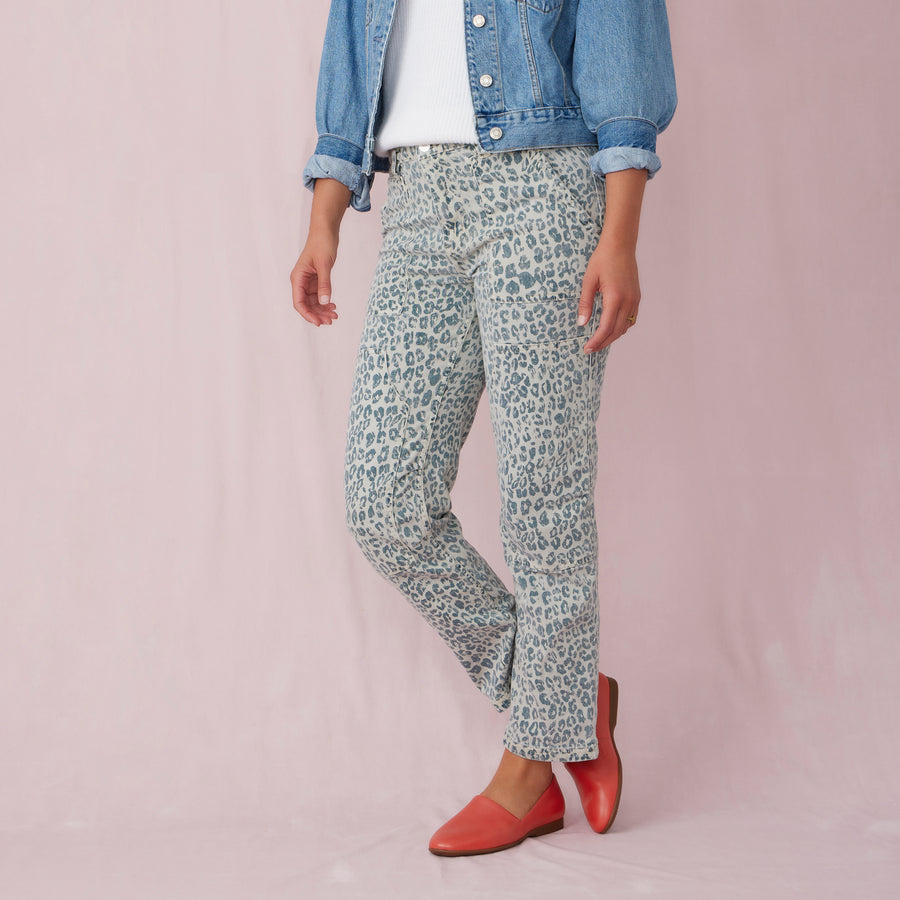A woman in patterned pants wearing red leather flats.