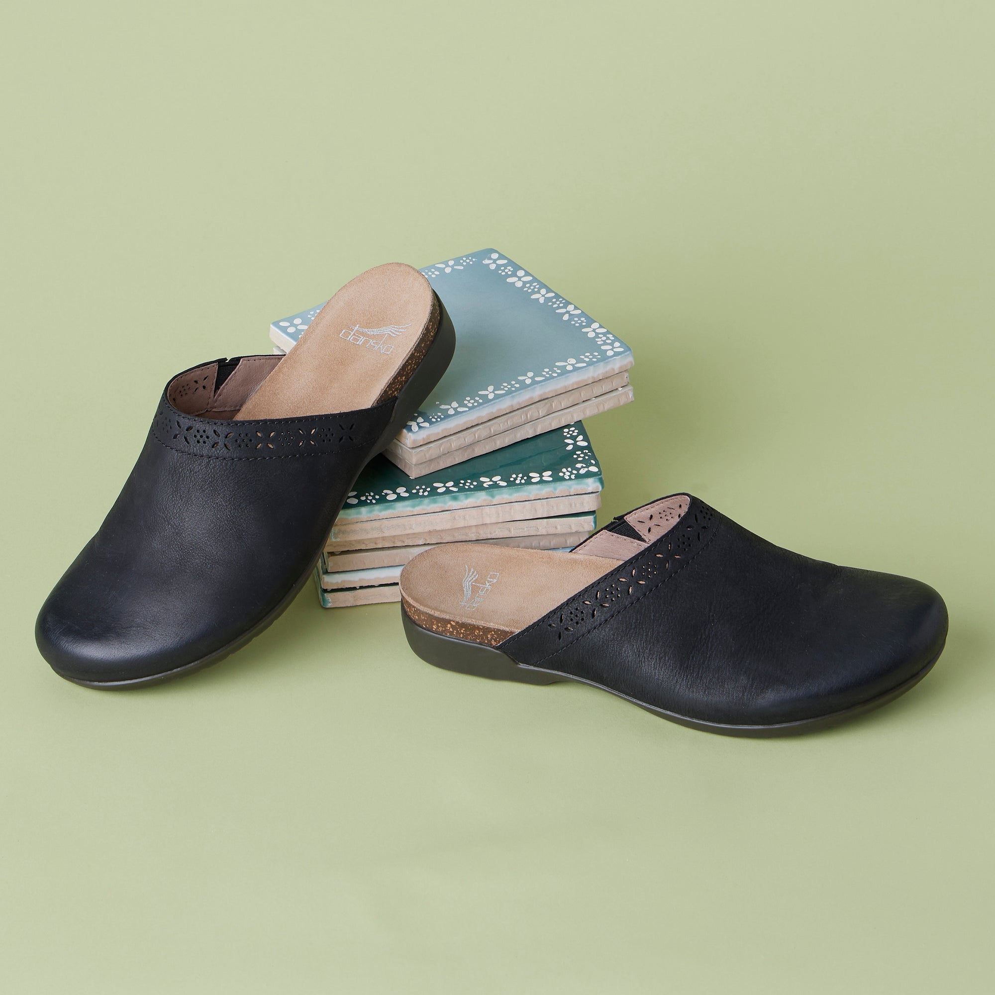Black leather slip-on mule shown with printed detail that appears on the uppers.