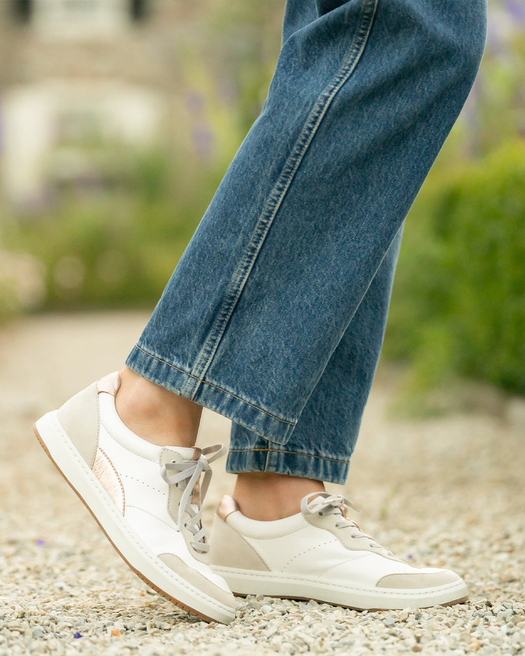 Close up of white and rose gold sneakers.