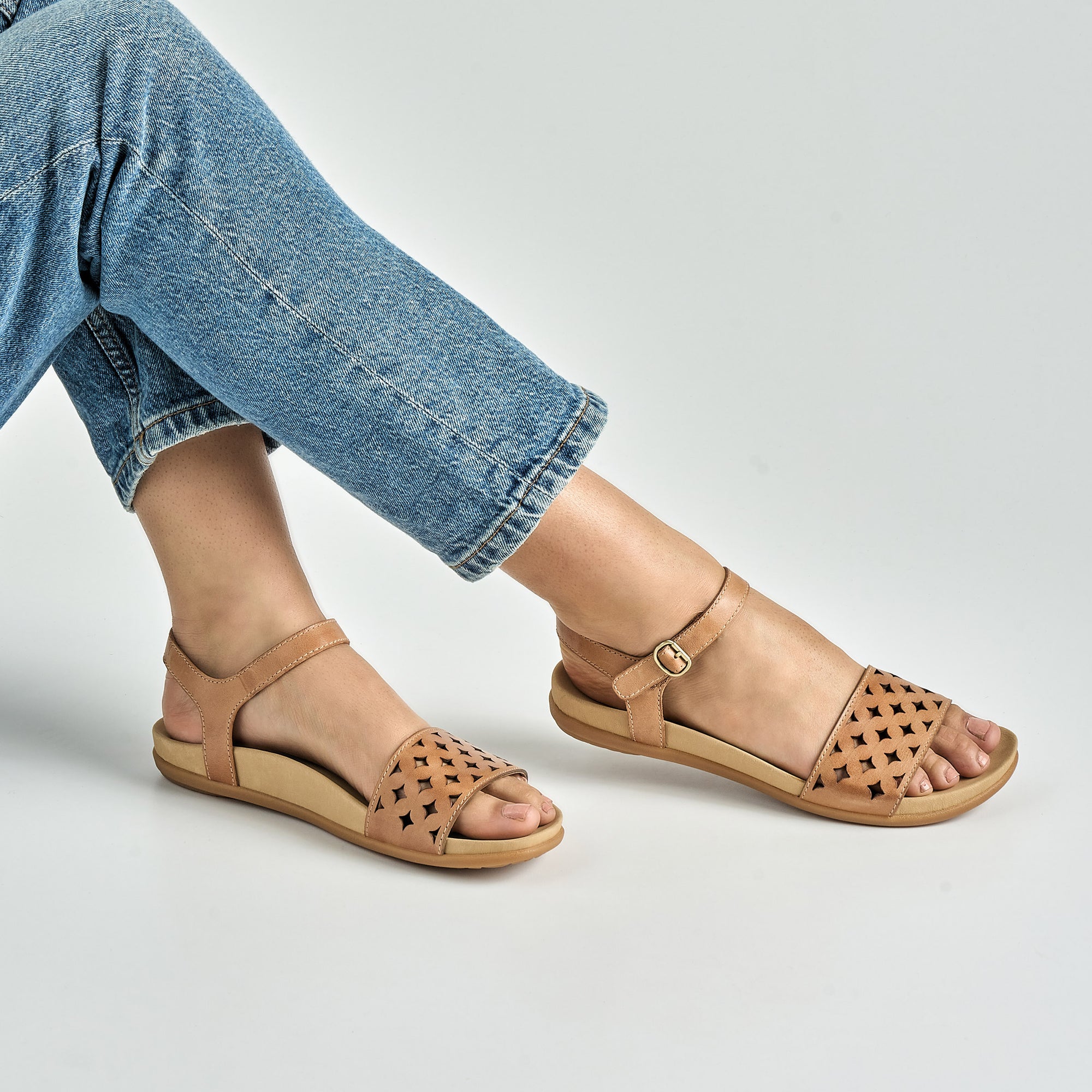 Close up of tan flat sandals.