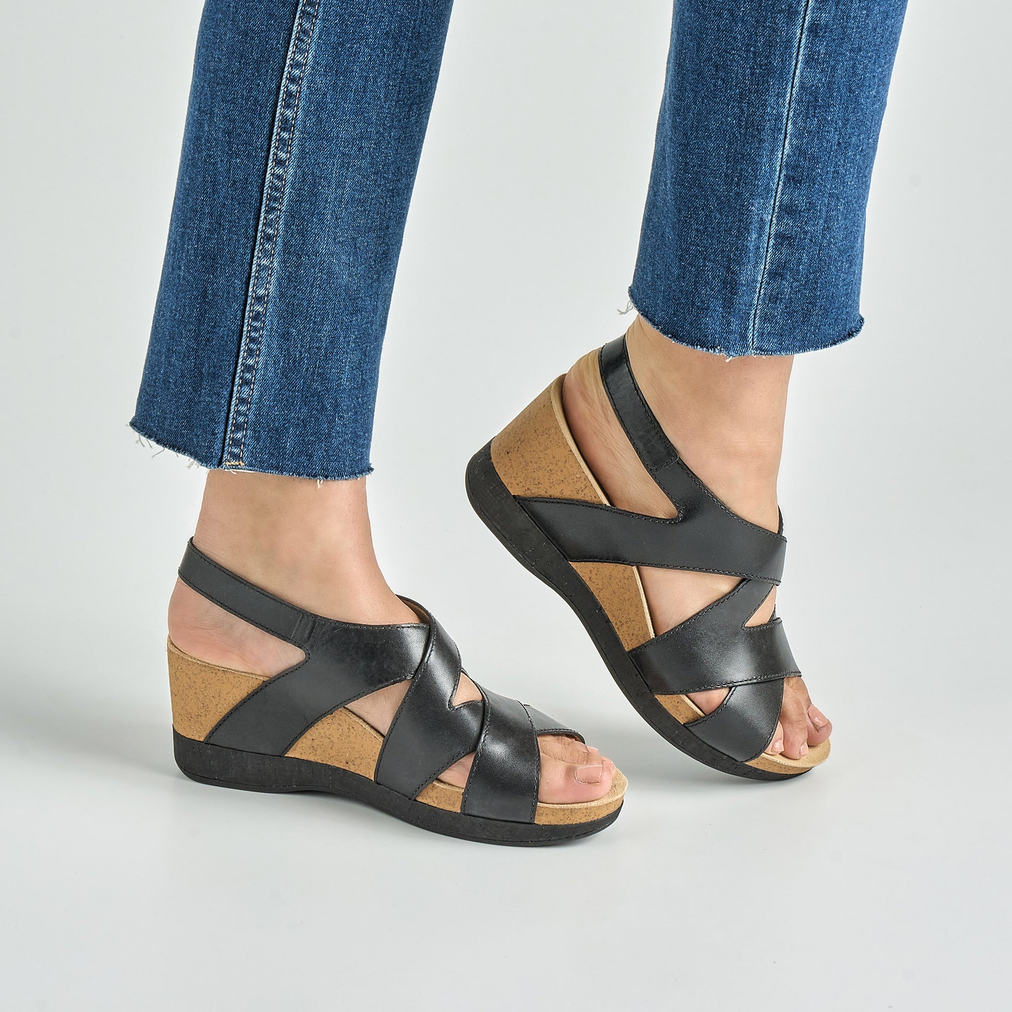 Close up of black ankle strap wedge sandal.