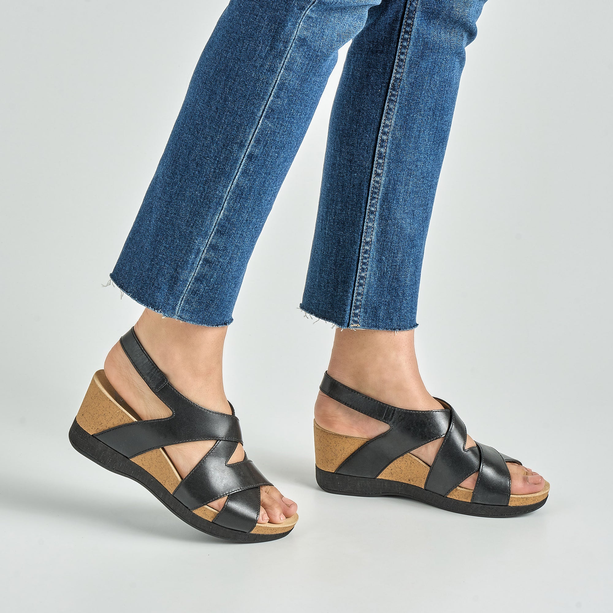 Close up of black ankle strap wedge sandal.