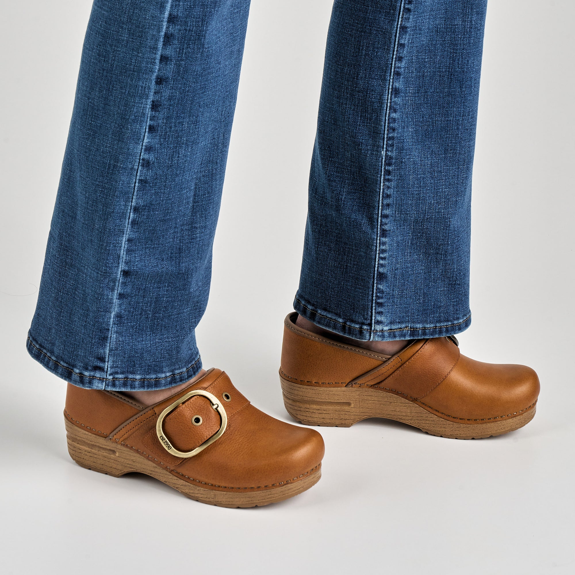 Close up of tan clog with large buckle.