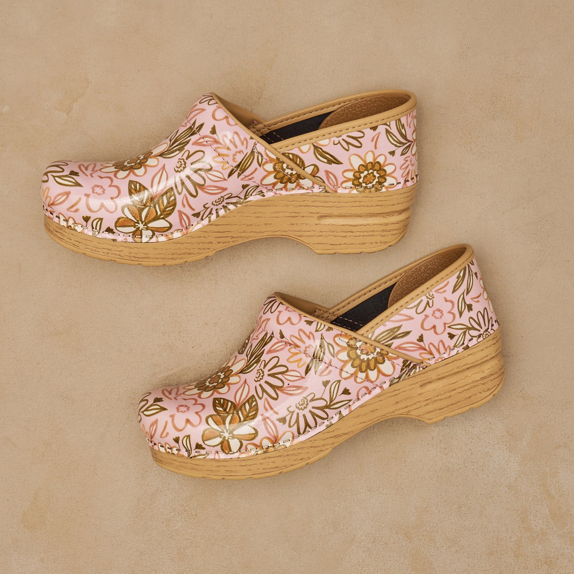 Close up of pink patterned clog on neutral backdrop.